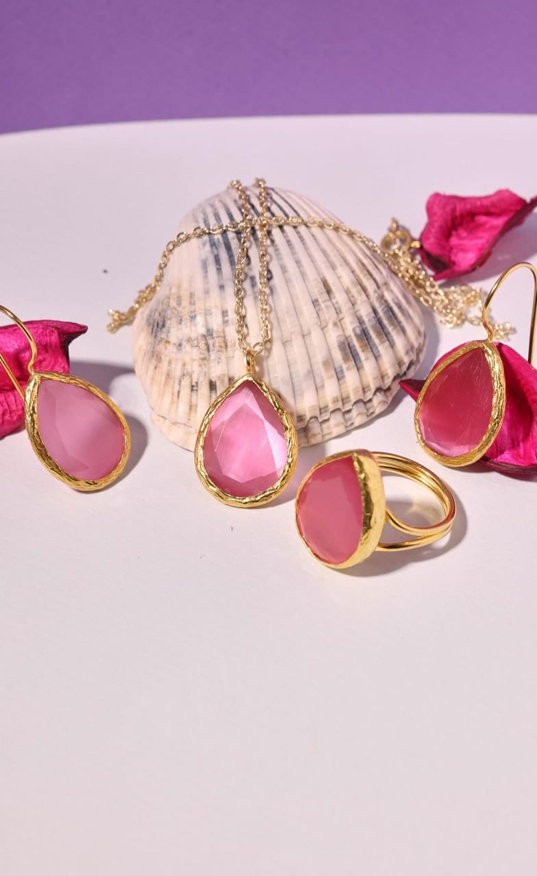 Gold pendant, drop earrings and ring set with pink stones around a seashell, with rose petals