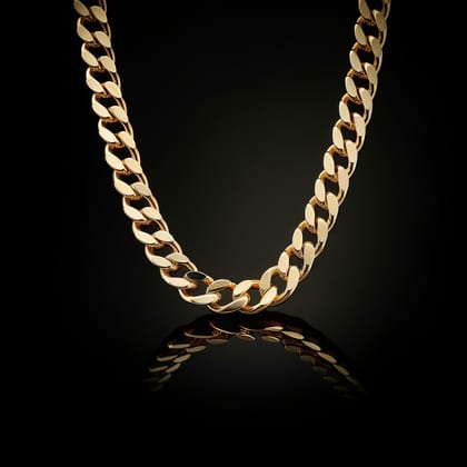 Gold Cuban link chain laid in a curve on black