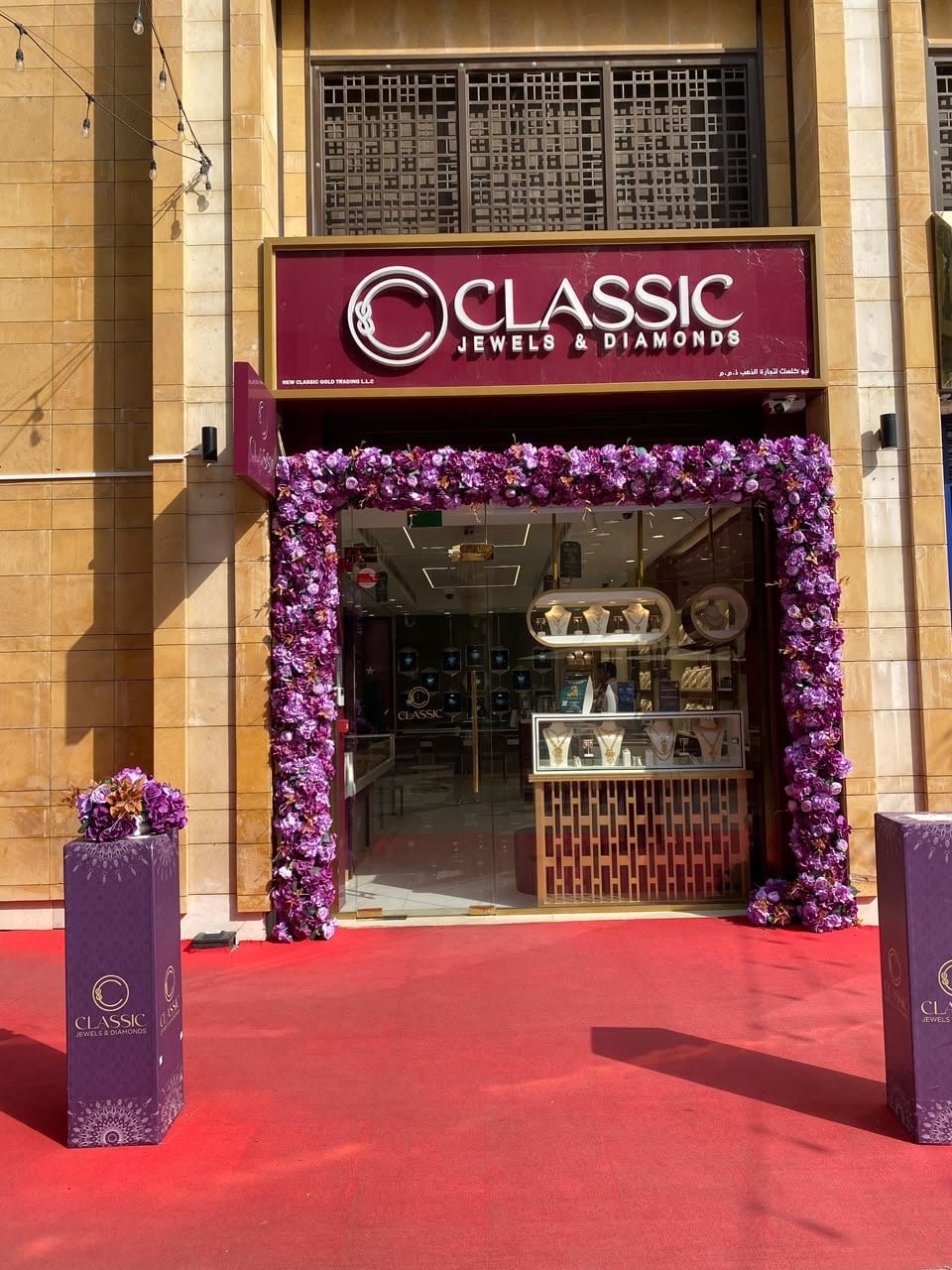 The Classic Jewels & Diamonds shop in the Gold Souq Extension, Deira: the burgundy sign over a glass front framed with purple flowers