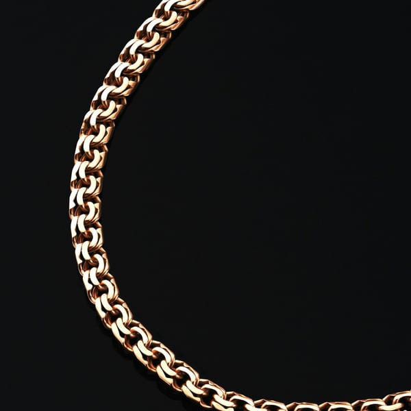 Close view of a gold double-link curb chain on black