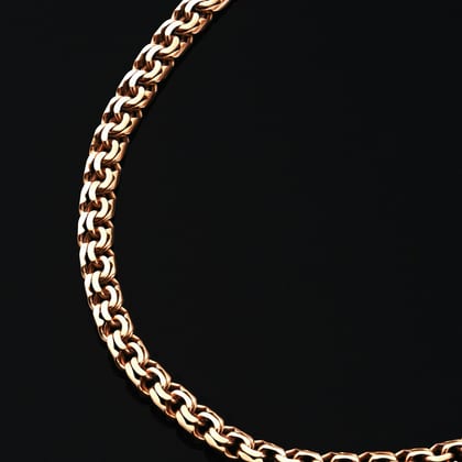 Close view of a gold double-link curb chain on black