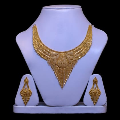 Gold bib necklace with a pointed filigree centre and matching drop earrings on a lilac bust