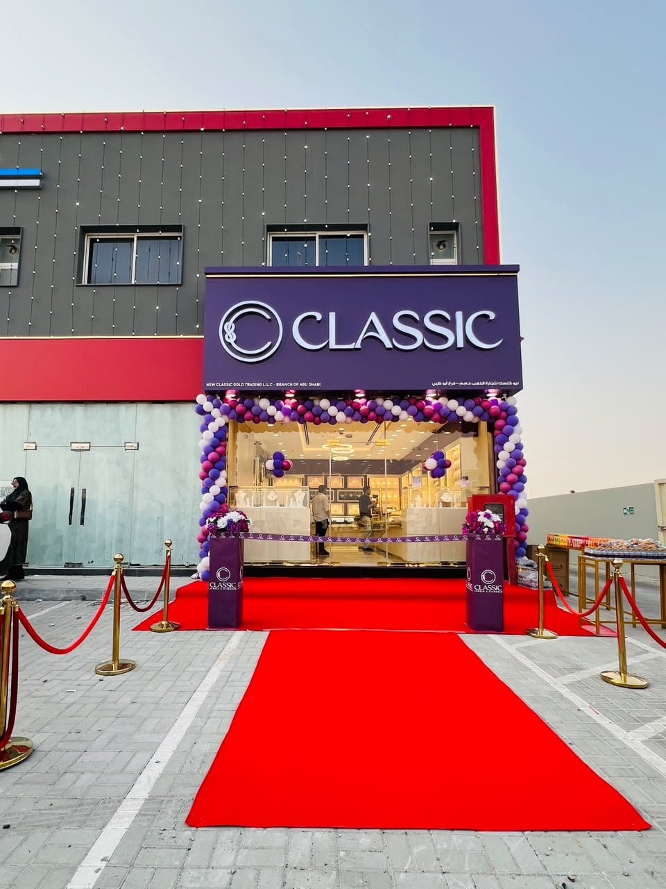The Madinat Zayed shop at dusk, with a red carpet and an arch of balloons at the door