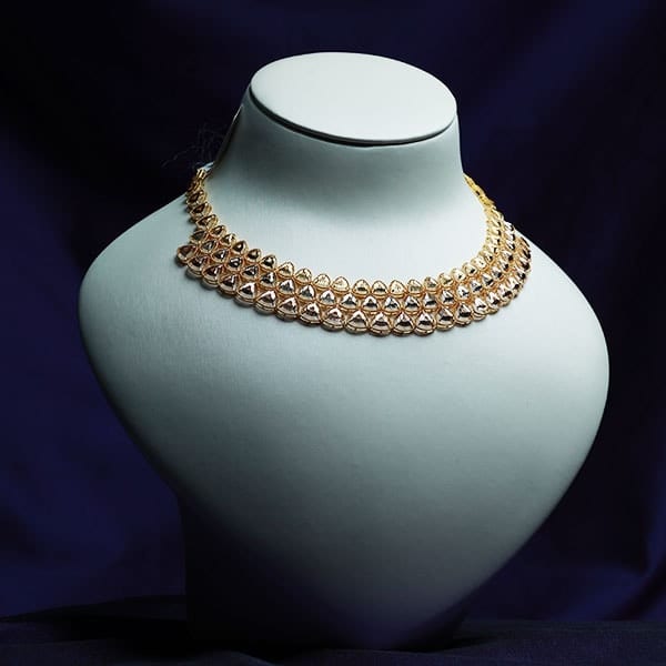 Turkish-style gold necklace with openwork filigree medallions on a white bust