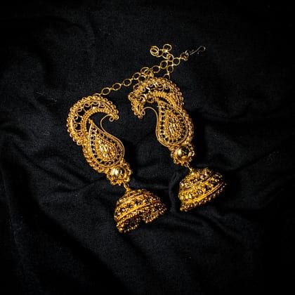 Gold paisley earrings with bell-shaped jhumka drops on black silk